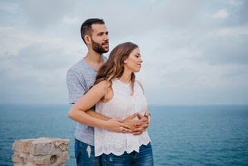 A man is hugging his girlfriend in the highland park near the sea in Spain