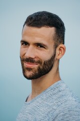 Fototapeta premium A Hispanic man with a beard near the sea in a highland park in Spain