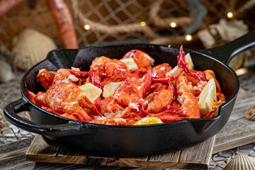 Large Skillet filled with Lobster Meat and Lemon Wedges.
