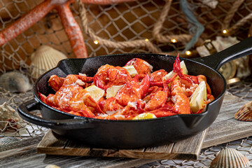 Large Skillet filled with Lobster Meat and Lemon Wedges.