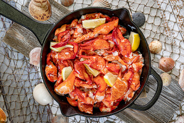 Large Skillet filled with Lobster Meat and Lemon Wedges.