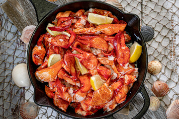 Large Skillet filled with Lobster Meat and Lemon Wedges.