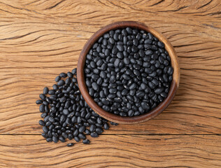 Fototapeta na wymiar Black beans in a bowl over wooden table