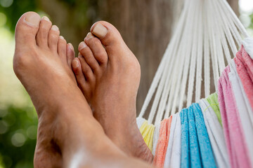 bare feet in the hammock resting in summer