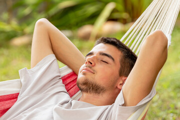 young man sleeping in the hammock in summer