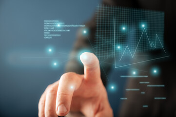 Hand of a businessman pointing to a glowing graph and digits presented on virtual interface