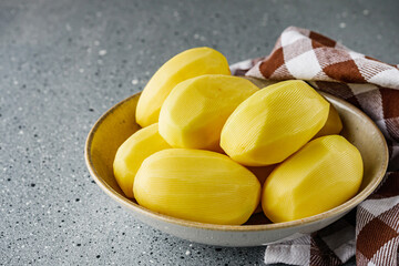 peeled potatoes on a gray stone background