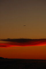 Plane over a cloud in sunset