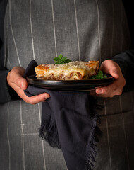 Food photography of lasagna, cheese, parmesan, oregano, hands, hold