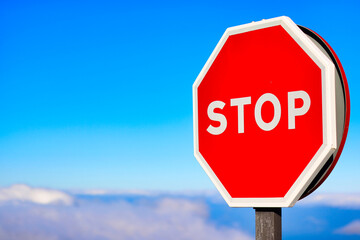 Closeup to stop sign over the clouds