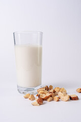 Almond bowl and almond drink on a glass, on a white table