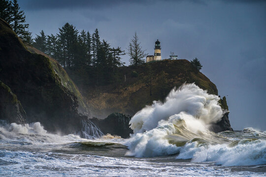 The storm waves from the Pacific Ocean crash against the rocky bluffs at Cape Disappointment, Washington, USA.