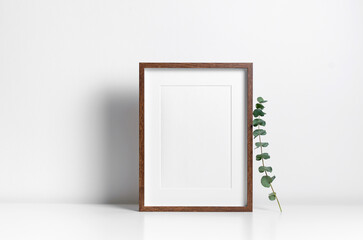 Vertical wooden frame mockup in white interior with copy space for artwork presentation