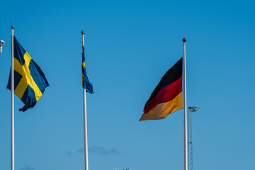 Swedish and german flag on flag poles.