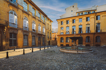 Fototapeta na wymiar View of provence typical city Aix en Provence with old house facade and famous old fountain in the morning