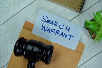 Search Warrant text on document above brown envelope with gavel.