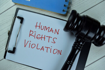 Concept of Human Rights Violation write on a paperwork with gavel isolated on Wooden Table.
