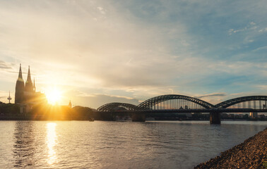  embankment of Rhine on background of Cologne Cathedral and Hohenzollern Bridge in Cologne Koel, Germany at sunset. Tourism and travel by Germany..