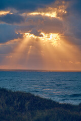 Naklejka na ściany i meble Sunset over the north sea with sunbeams. High quality photo