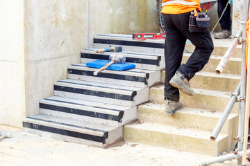 Concrete steps under construction as a team of builders install heavy concrete blocks