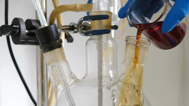 Chemical factory with laboratory. Formalin production testing. Worker pouring liquid into transparent bowl. Manufacture drugs for medical supplies of pharmacy industry. Pharmacology specialist at work