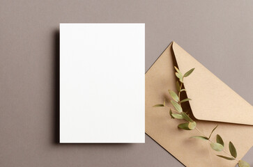 Blank greeting or invitation card mockup with envelope and dry eucalyptus twig
