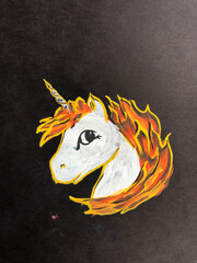 drawing of a unicorn with a fiery mane on a black background.