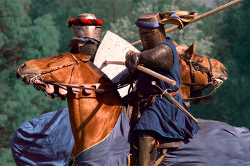 Two knights attack each other with galloping spears. Knightly tournament on horseback. Knight duel...