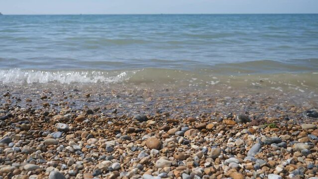 Sea waves calmly crushing on the pebble beach.