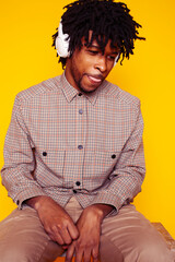 Young handsome african american guy student posing cheerful and gesturing on yellow background, lifestyle people concept