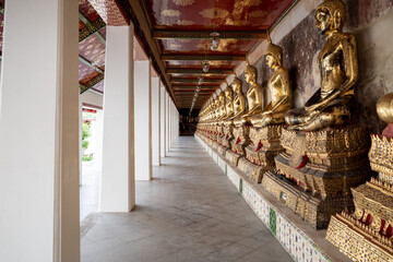Row of buddha statues along corridor of Wat Suthat Thepwararam Ratchaworahawihan temple in Bangkok, Thailand 