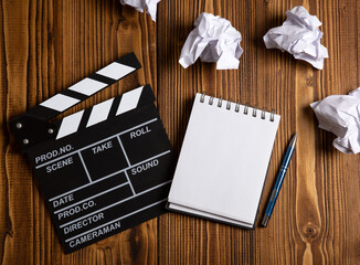paper and a crumpled paper with cinematic clapperboard on a table