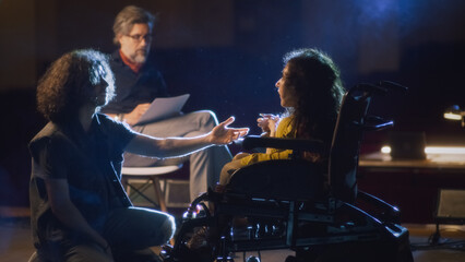 Actress with spinal muscular atrophy and an actor rehearsing a romantic scene for a theater performance and listening to the director's instructions