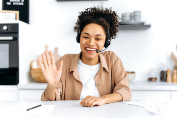 Positive confident curly-haired young african american woman with headset, call center worker,...