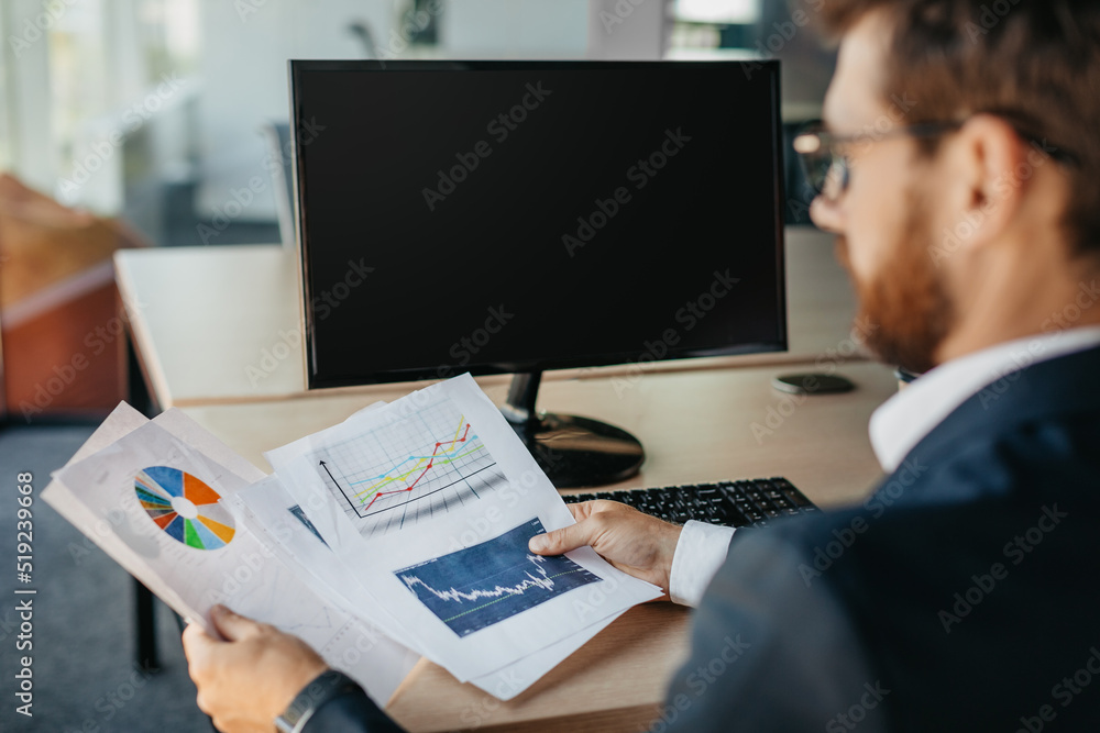 Aufkleber successful entrepreneur reading financial reports, sitting at workplace with computer with black emp
