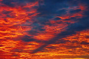 Dramatic bloody sky. Fiery sunset, sky on fire. Armageddon, apocalypse, heaven and hell, abstract dark red background. Red colorful glowing sky, vivid clouds at twilight. Majestic orange sundown.