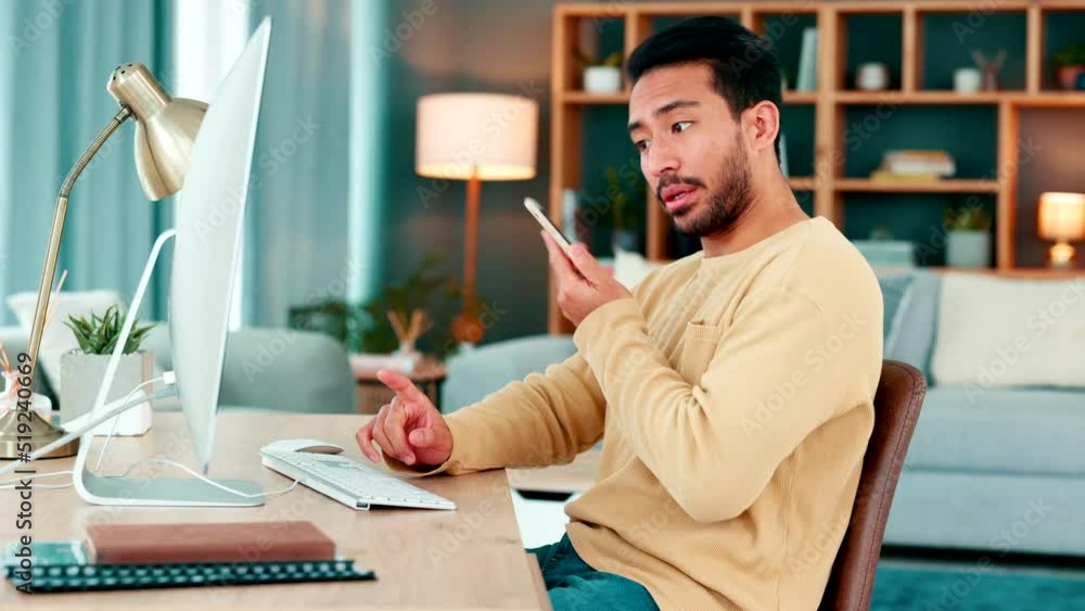 Aufkleber Young IT specialist talking on a phone call while working on a desktop computer alone at home. One young Asian computer programer having a conversation and typing an email while working a desk