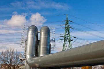 pipeline and power line pylon, in the photo, pipeline close-up, power line pylon and blue sky in the background