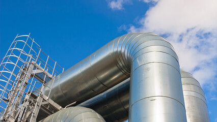 pipeline and power line pylon, in the photo, pipeline close-up, power line pylon and blue sky in...