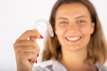 Beautiful smiling young woman with aligner.