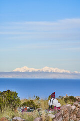 Native woman watching to Lake Titicaca and Ancohuma snow peak