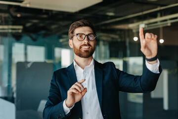Successful entrepreneur in formalwear selecting something on virtual screen, standing in modern...