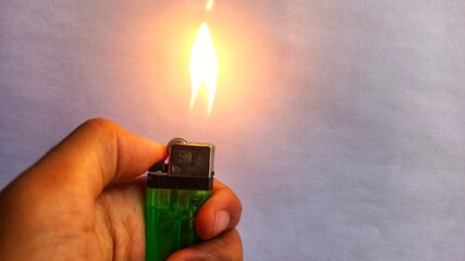 A gas lighter that is being lit or lit to burn something