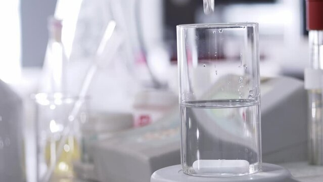Close-up of scientist's hands measuring ph. Selective focus.