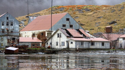 Derelict, rusted buildings along the shore at the old whaling station at Leith Harbor, South...