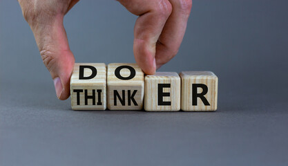 Doer or thinker symbol. Concept words Doer or thinker on wooden cubes. Businessman hand. Beautiful grey table grey background. Business and doer or thinker concept. Copy space.