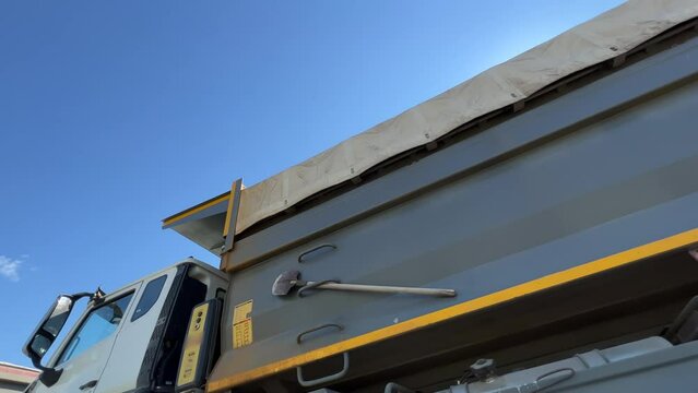 Dump trucks stand at the construction site or quarry waiting for unloading. Low angle view. Extreme wide angle shot