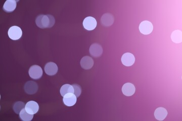 Blurred view of festive lights on purple background. Bokeh effect