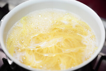 Cooking pasta in saucepan on stove, closeup