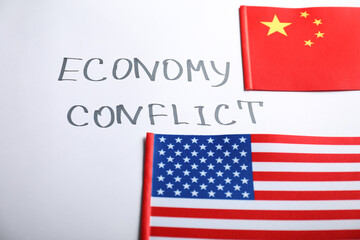 USA and China flags near words ECONOMY CONFLICT on white background